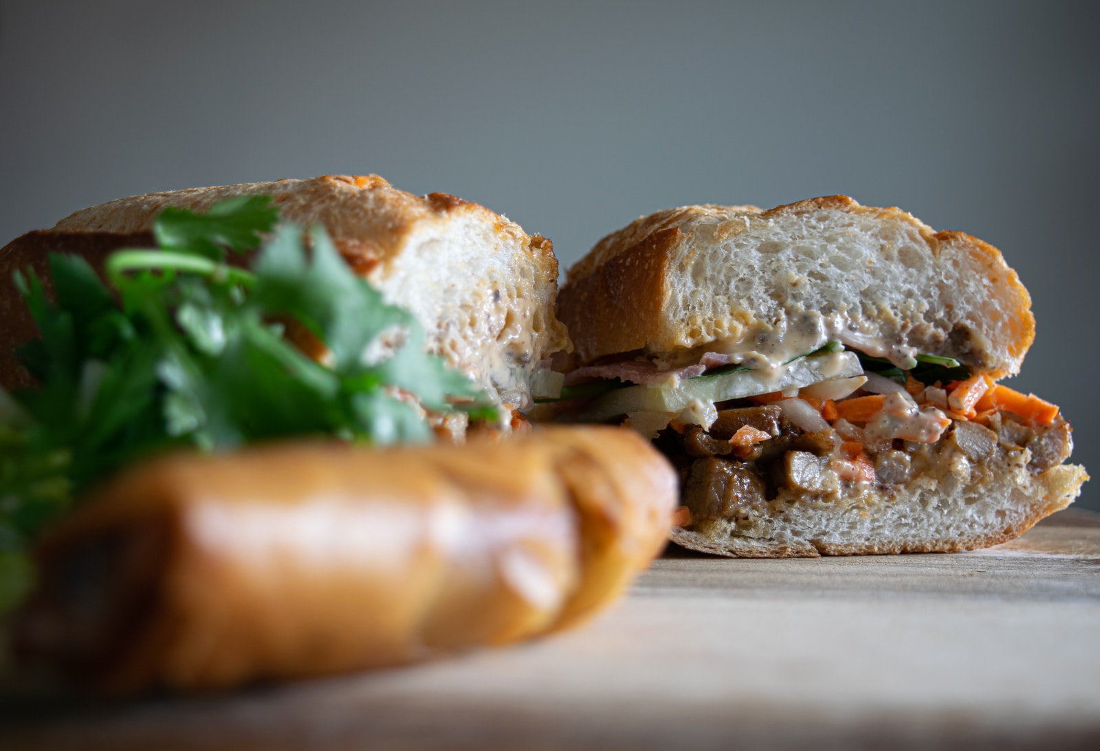 bread with green vegetable on brown wooden table